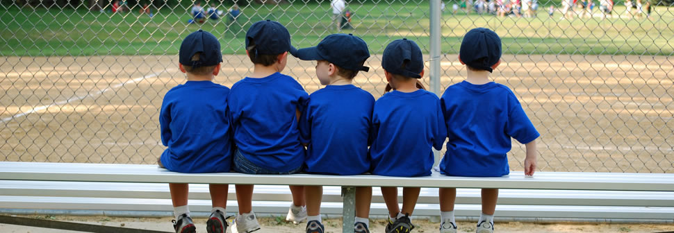 five-tee-ball-teammates-sitting-on-the-bench-watching-the-game