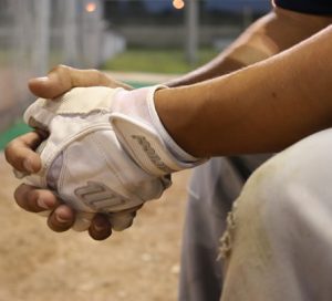 adult-baseball-player-sitting-on-bench-wearing-batting-gloves