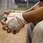 adult-baseball-player-sitting-on-bench-wearing-batting-gloves